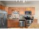 Galley kitchen with stainless steel appliances, granite countertops, and warm wood cabinets at 7212 S Blackhawk St # 1-103, Englewood, CO 80112