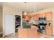 Modern kitchen features stainless steel appliances, center island with a granite top, and laundry closet at 7212 S Blackhawk St # 1-103, Englewood, CO 80112