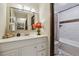 Well-lit bathroom featuring a white vanity, a large mirror, and a shower/tub combination with tile surround at 519 Wright St # 106, Lakewood, CO 80228