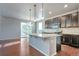 Open kitchen with granite counters, dark cabinets, stainless appliances and center island with pendant lights at 15955 E Otero Cir, Centennial, CO 80112
