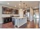 Well-appointed kitchen with stainless steel appliances, a large center island, granite countertops, and dark cabinets at 15955 E Otero Cir, Centennial, CO 80112