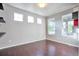 Inviting room with hardwood floors, bright natural light from three windows, and minimalist decor at 15955 E Otero Cir, Centennial, CO 80112