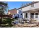 Private backyard with stone patio seating area, shed, and lush green grass at 1206 E Phillips Pl, Littleton, CO 80122