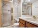 Bathroom showcasing shower, sink, neutral tile, and a glass door at 1206 E Phillips Pl, Littleton, CO 80122