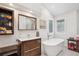 Bathroom featuring a soaking tub, walk-in shower, and a wooden vanity at 1206 E Phillips Pl, Littleton, CO 80122