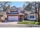 Charming two-story home featuring a brick facade, attached two car garage, and well-maintained front yard at 1206 E Phillips Pl, Littleton, CO 80122