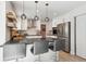 Modern kitchen with stainless steel appliances, breakfast bar, and wooden floating shelves at 1206 E Phillips Pl, Littleton, CO 80122