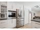 Modern kitchen with stainless steel appliances, white cabinetry, and built in oven at 1206 E Phillips Pl, Littleton, CO 80122