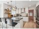 Modern kitchen with stainless steel appliances, breakfast bar, and wooden floating shelves at 1206 E Phillips Pl, Littleton, CO 80122