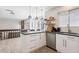 Modern kitchen with stainless steel appliances, breakfast bar, wooden shelves, and backyard access at 1206 E Phillips Pl, Littleton, CO 80122