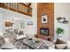 Bright living room with a brick fireplace, high ceiling, and loft overlook at 1206 E Phillips Pl, Littleton, CO 80122