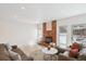 Bright living room with a brick fireplace, neutral paint, wood floors, and comfortable leather furniture at 1206 E Phillips Pl, Littleton, CO 80122