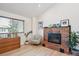Bedroom featuring a brick fireplace, wood floors, a comfy chair, and a large window at 1206 E Phillips Pl, Littleton, CO 80122