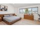 Comfortable bedroom with wood floors, large window, and streamlined wooden dresser at 1206 E Phillips Pl, Littleton, CO 80122