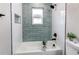 This bathroom has white and light-blue tiles with black fixtures and a white tub at 116 S 10Th Ave, Brighton, CO 80601