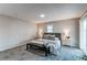 Bright bedroom with gray carpet, bedside tables, and a comfortable bench at 116 S 10Th Ave, Brighton, CO 80601