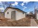 A detached garage painted white with a gray X-brace door and small windows at 116 S 10Th Ave, Brighton, CO 80601