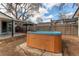 A backyard view of a hot tub surrounded by a wooden fence and covered patio at 116 S 10Th Ave, Brighton, CO 80601