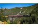 Scenic view of a vintage train crossing a bridge with mountains and trees in the background at 2152 Bighorn Rd # 203, Georgetown, CO 80444