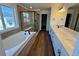 Sleek bathroom with double vanity, soaking tub, glass shower, and wood-look tile floors at 4609 Thistle Dr, Brighton, CO 80601