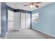 Bedroom with a ceiling fan, closet space, and two-tone blue walls at 110 Gold Maple St, Brighton, CO 80601