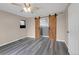 Bright bedroom with barn door to bathroom, fan, and gray floors at 110 Gold Maple St, Brighton, CO 80601