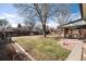 Lush backyard featuring a covered patio, well-maintained lawn, and mature trees creating a serene outdoor space at 2993 S Zenobia St, Denver, CO 80236