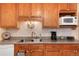 Kitchen sink with wooden cabinets, a tile backsplash, and modern appliances at 2993 S Zenobia St, Denver, CO 80236