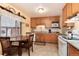 Bright kitchen featuring oak cabinets, white appliances, and a cozy breakfast nook with backyard views at 2993 S Zenobia St, Denver, CO 80236