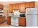 Another view of the kitchen featuring white appliances, oak cabinets, and a white refrigerator at 2993 S Zenobia St, Denver, CO 80236