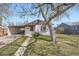 Charming home with a well-maintained front yard, walkway, mature trees, and carport at 1280 S Quitman St, Denver, CO 80219