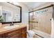 Bathroom with a dark wood vanity, a neutral tile shower, and glass door at 10590 Soulmark Way, Highlands Ranch, CO 80126
