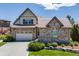 Charming two-story home boasts a stone facade, three-car garage, and inviting curb appeal on a sunny day at 10590 Soulmark Way, Highlands Ranch, CO 80126