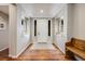 Bright foyer features hardwood floors, recessed lighting, decorative mirrors and a bench, offering a welcoming entrance at 10590 Soulmark Way, Highlands Ranch, CO 80126