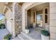 Inviting front porch with stone accents, decorative plants, and an elegant front door at 10590 Soulmark Way, Highlands Ranch, CO 80126