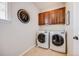 Convenient laundry room with modern washer and dryer, storage cabinets, and a functional layout at 10590 Soulmark Way, Highlands Ranch, CO 80126