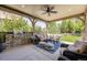 Inviting covered patio featuring an outdoor kitchen, ceiling fan, and comfortable seating area at 10590 Soulmark Way, Highlands Ranch, CO 80126