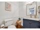 Stylish powder room featuring a vanity, gold faucet, and decorative mirror for guests at 10590 Soulmark Way, Highlands Ranch, CO 80126