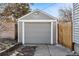 A one-car garage with an overhead door and gray siding at 1665 Boston St, Aurora, CO 80010