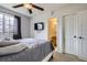 Bedroom boasts gray bedding, TV, closet and adjacent bathroom with modern lighting at 2139 Coronado Pkwy # B, Denver, CO 80229