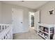 Bedroom features a crib, changing table and nearby laundry closet in a well-lit room at 2139 Coronado Pkwy # B, Denver, CO 80229