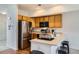 Well-lit kitchen with stainless steel refrigerator and adjacent breakfast bar at 2139 Coronado Pkwy # B, Denver, CO 80229