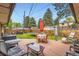 A lovely backyard with a wood deck, a seating area, a dining table, a grill and some beautiful landscaping at 555 W Mansfield Ave, Englewood, CO 80110