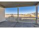 Covered back porch with views of open fields, a clear blue sky, and neighboring homes in the distance at 711 N Waterloo Ct, Aurora, CO 80018