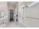 Bright bathroom with white tiled shower, white cabinets, granite countertops, and modern fixtures at 711 N Waterloo Ct, Aurora, CO 80018