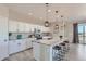 Bright, modern kitchen with white cabinets, granite countertops, stainless steel appliances, and a large island at 711 N Waterloo Ct, Aurora, CO 80018