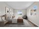 A furnished bedroom with a large window, decorative art, and a neutral color palette at 10211 Ura Ln # 1-202, Thornton, CO 80260