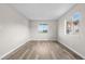 A sunlit bedroom with light wood floors and two bright windows at 10211 Ura Ln # 1-202, Thornton, CO 80260