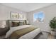 A cozy, furnished bedroom with a plush rug, queen bed, bright window, and modern decor at 10211 Ura Ln # 1-202, Thornton, CO 80260