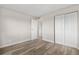 Spacious bedroom with light wood floors and bright white closet doors at 10211 Ura Ln # 1-202, Thornton, CO 80260
